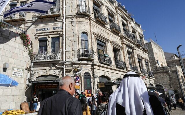 People walk past the Imperial Hotel located next to the Jaffa Gate in the Christian Quarter of Jerusalem's Old City on November 29, 2019. (Gali Tibbon/AFP)